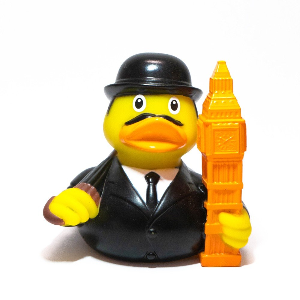 Pato de goma Big Ben Duck con traje negro, sombrero bombín y réplica del Big Ben en la mano, un homenaje a la cultura británica.